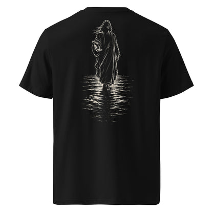 A black short-sleeve t-shirt shown from the back, featuring a large white graphic print of a hooded figure walking through water with a reflection below.