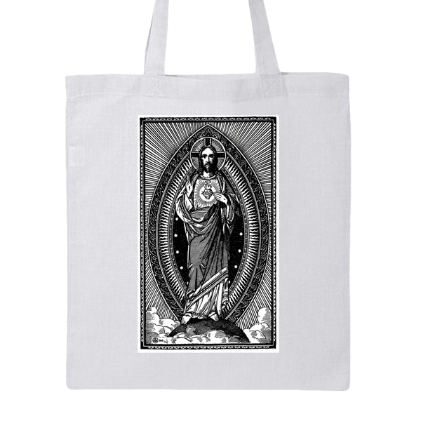 A white canvas tote bag with a large black-and-white graphic print of the Sacred Heart of Jesus on the front, shown against a plain white background.